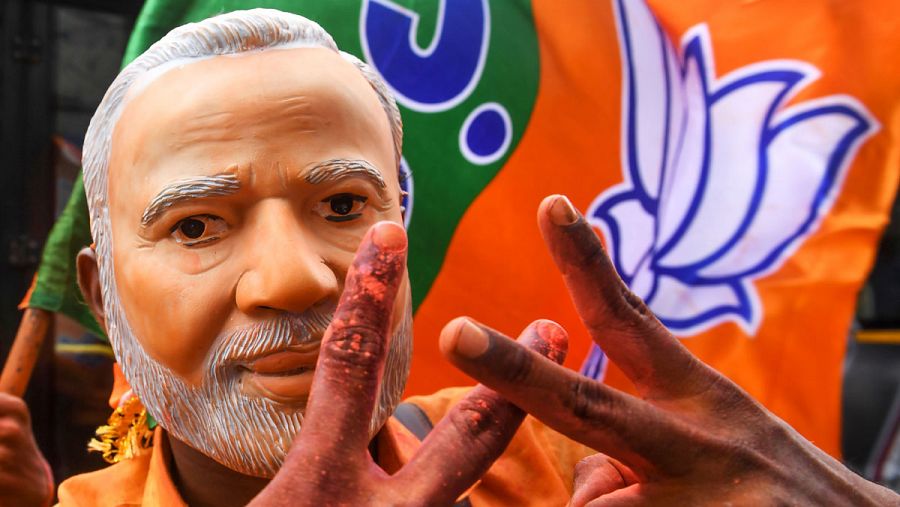 Un seguidor del Partido Bharatiya Janata celebra los resultados de las elecciones generales con una máscara del Primer Ministro, Narendra Modi.