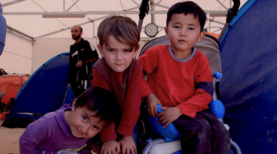 Niños afganos en la entrada del campo de refugiados de Malakasa