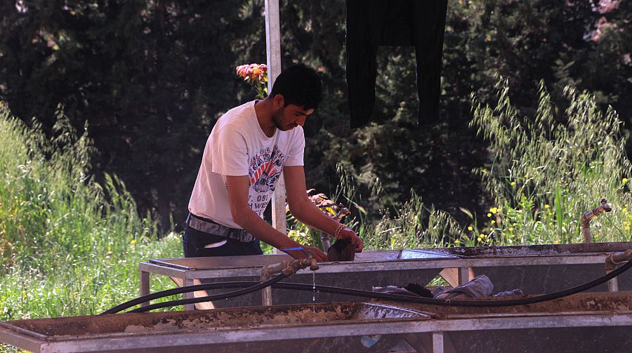 Ami, afgano de 23 años, lava su ropa.