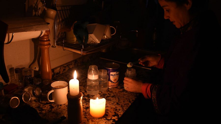Una mujer enciende unas velas en su casa de Montevideo (Uruguay) tras sufrir un apagón que ha dejado al país sin luz durante horas.