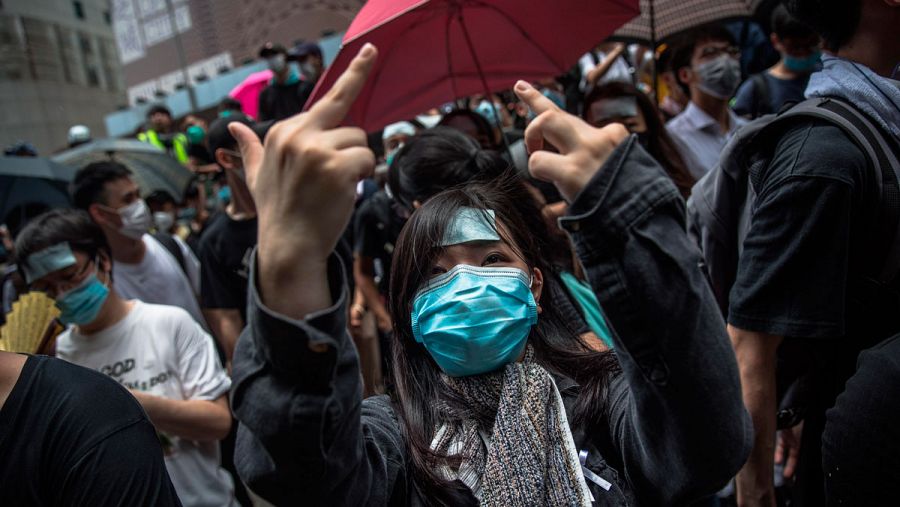 Una manifestante hace un gesto a los policías mientras varios activistas se concentran en los alrededores de la sede de la policía Wanchai en Hong Kong (China), este viernes.