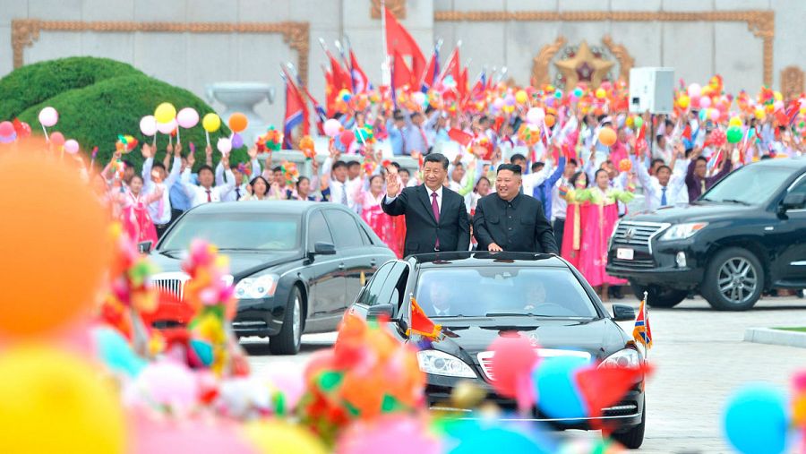 El líder norcoreano Kim Jong Un (R) y el presidente chino Xi Jinping saludaron a la multitud a su llegada a Pyongyang