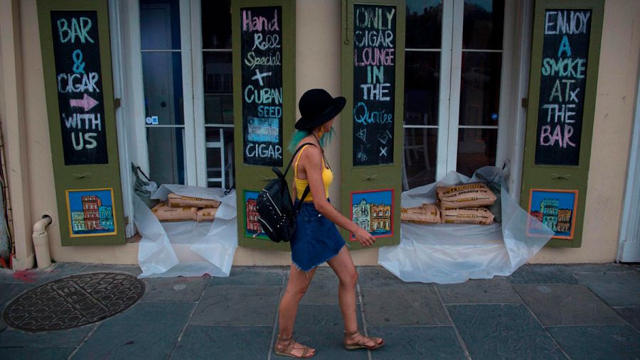 Una mujer pasa frente a un bar protegido con bolsas de arena en el Barrio Francés de Nueva Orleans. 