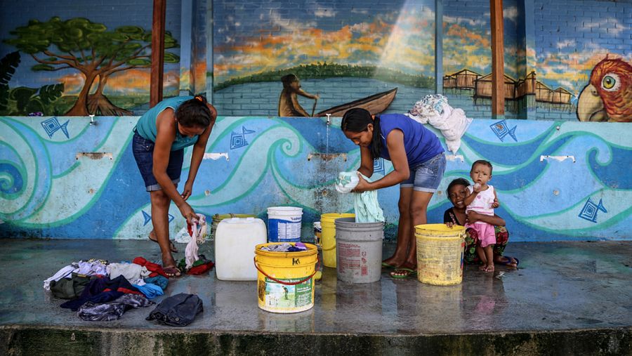 Las mujeres lavan su ropa en el refugio de Pintolandia, en Boa Vista. El suministro de agua y el saneamiento se encuentran en malas condiciones en el refugio.