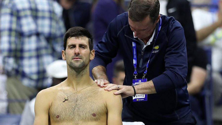 Djokovic es atendido de su hombro izquierdo durante su encuentro ante Wawrinka