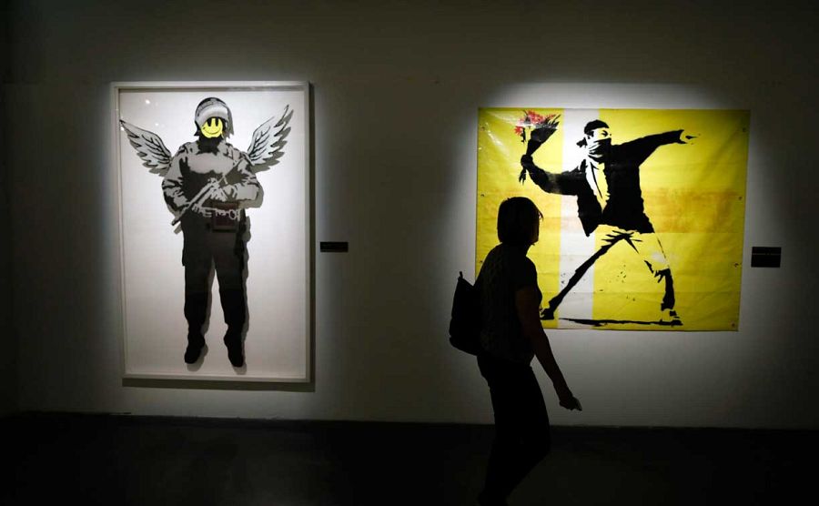 Una mujer observa las obras del artista británico Banksy durante la exposición 'El Arte de Banksy' en Herzliya, cerca de Tel Aviv, Israel, en abril de 2017
