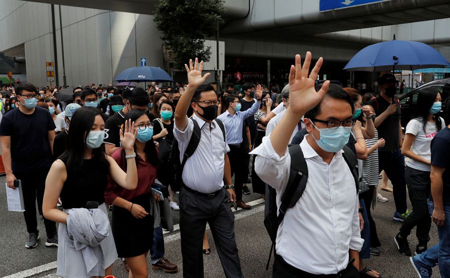 Trabajadores de las oficinas en el centro de Hong Kong protestan contra la prohibición del uso de máscaras.