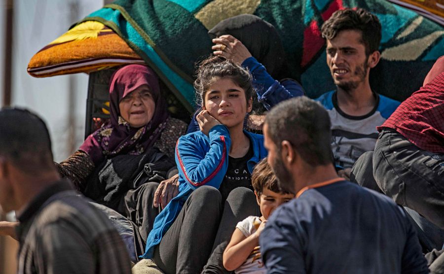 Civiles sirios árabes y kurdos llegan a la ciudad de Hassakeh después de huir después del bombardeo turco en las ciudades del noreste de Siria a lo largo de la frontera turca.