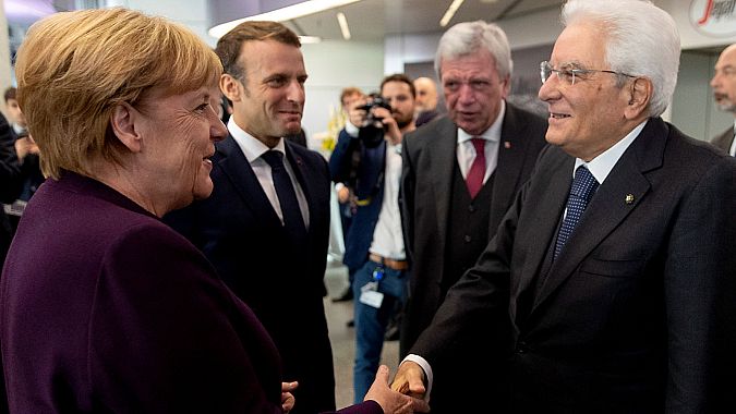 La canciller alemana, Angela Merkel, saluda al presidente de Italia, Sergio Mattarella, en presencia del presidente de Francia, Emmanuel Macron