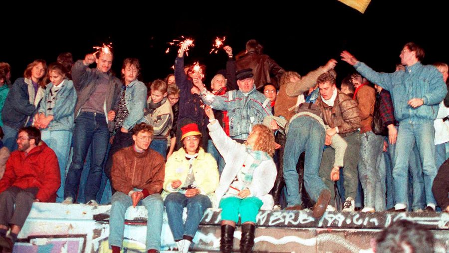 Una multitud de personas celebra sobre el muro de Berlín la apertura de la frontera entre ambas Alemania el 9 de noviembre de 1989