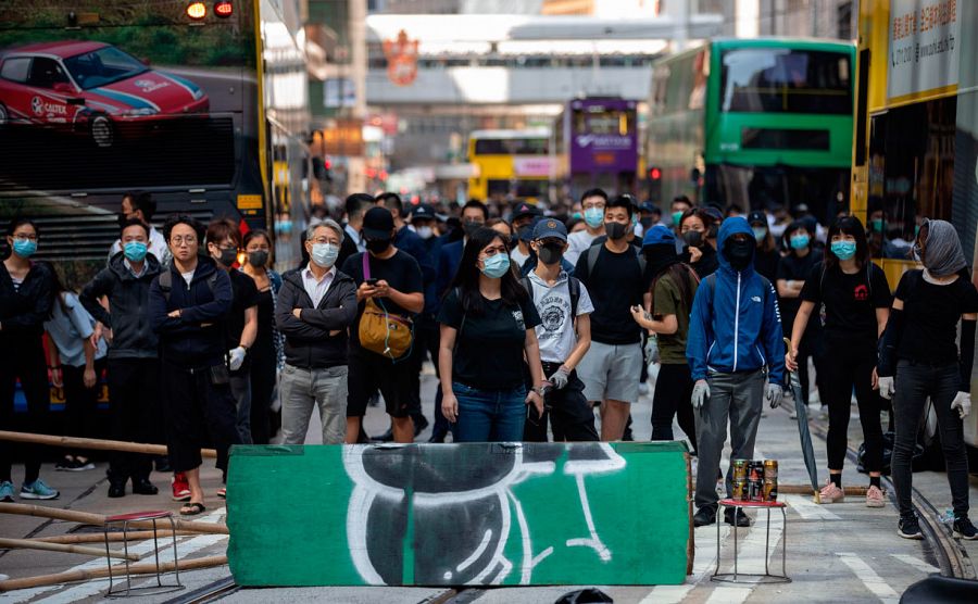Trabajadores de las oficinas en el centro de Hong Kong ocupan las calles en señal de protesta