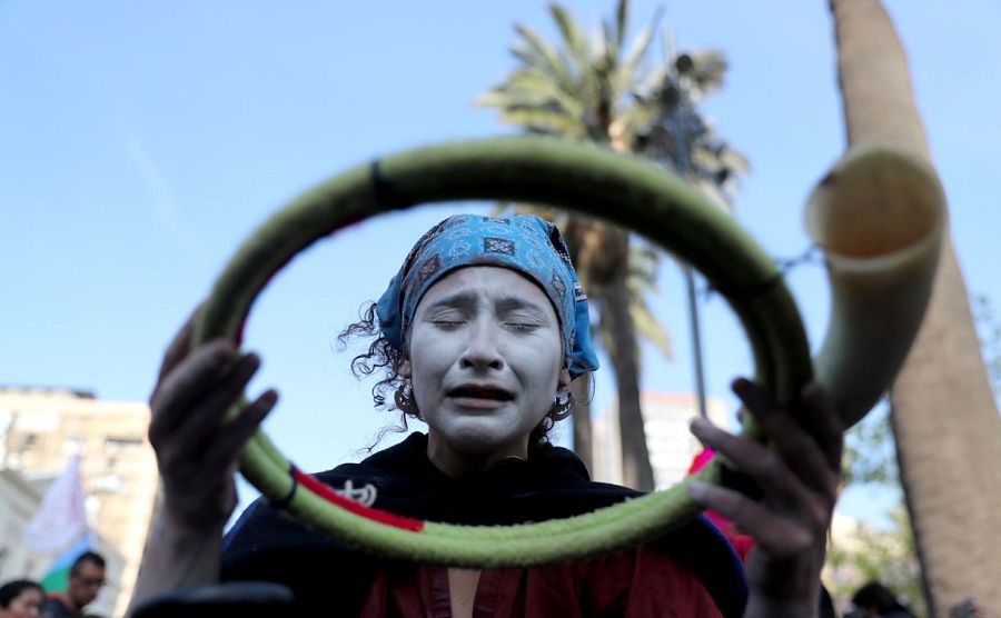Una indígena mapuche, con la cara pintada, se prepara con uno de sus ritos antes de participar en una de las manifestaciones ciudadanas en Santiago.