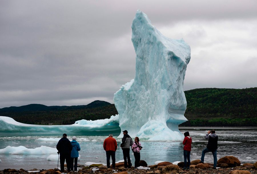 Un grupo de turistas observan un iceberg en la costa de Canadá.