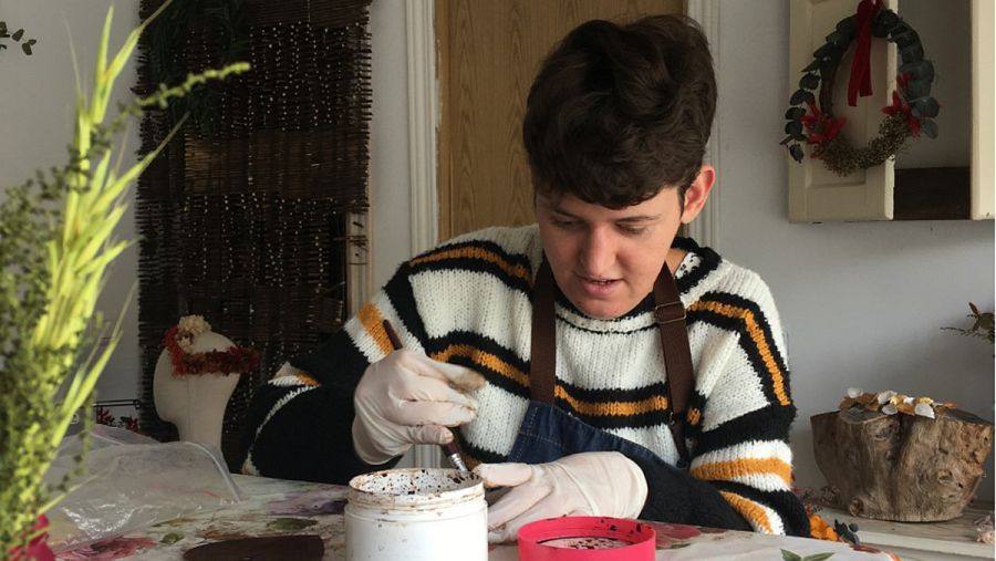 Xhulia pintando corazones de madera