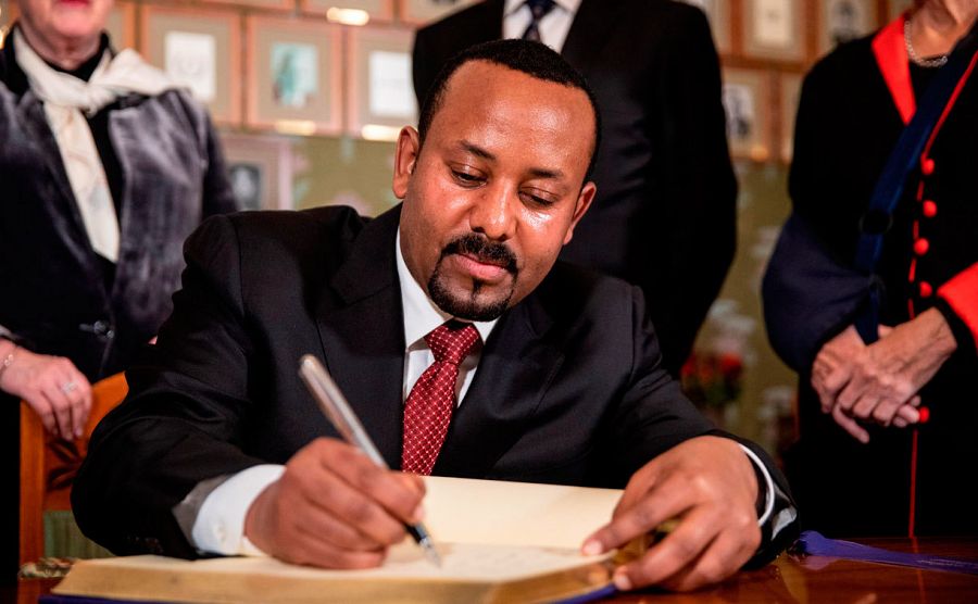 El primer ministro etíope, Abiy Ahmed, firma el libro de los galardonados a su llegada al Ayuntamiento de Oslo.