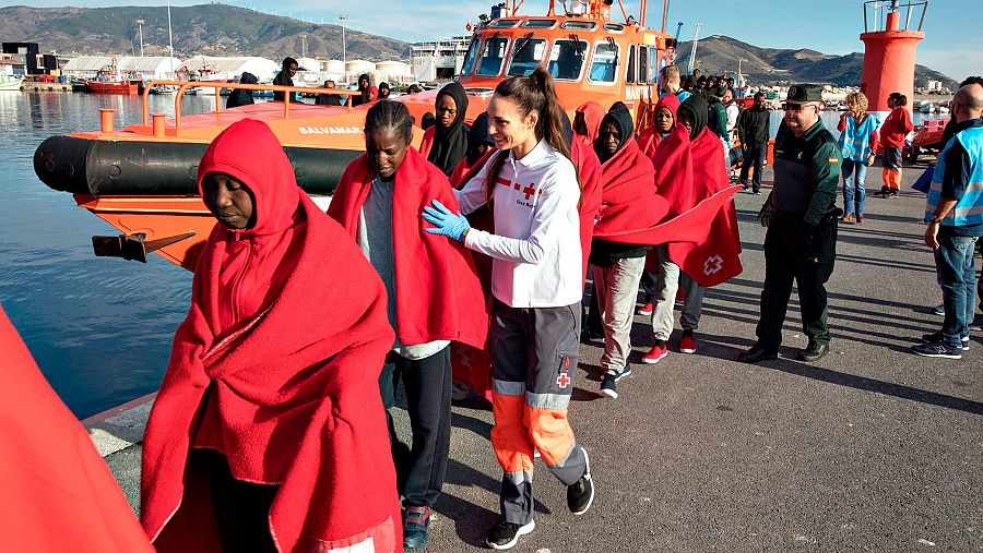 Efectivos de la Guardia Civil y miembros de Salvamento Marítimo reciben a varios inmigrantes que han sido traslados en la Salvamar Hamal al puerto de Motril