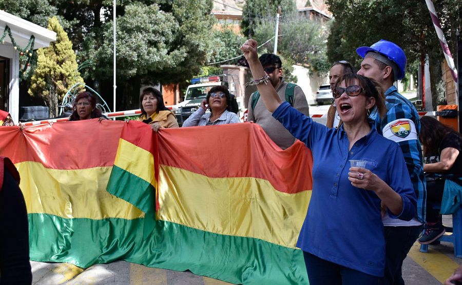 Un grupo de personas favorables al nuevo gobierno de Bolivia protesta en la entrada al barrio donde se encuentra la embajada de México, en La Paz (Bolivia).