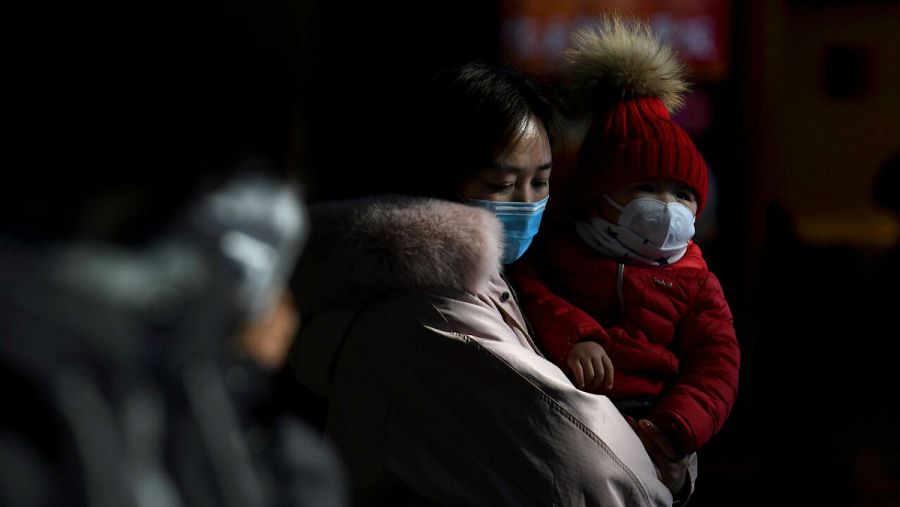 Una mujer junto a su hijo llevan máscaras para prevenir el contagio del coronavirus.