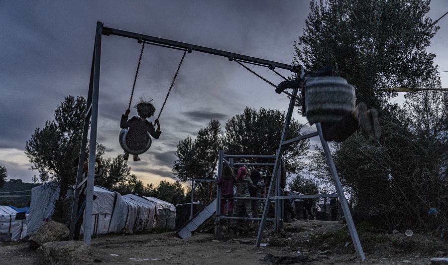 Niños juegan en un columpio a las afueras de Moria