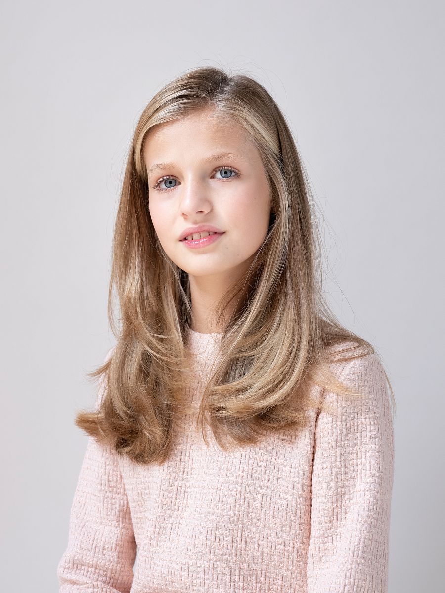 Leonor, con el cabello suelto, lleva un vestido en rosa palo.