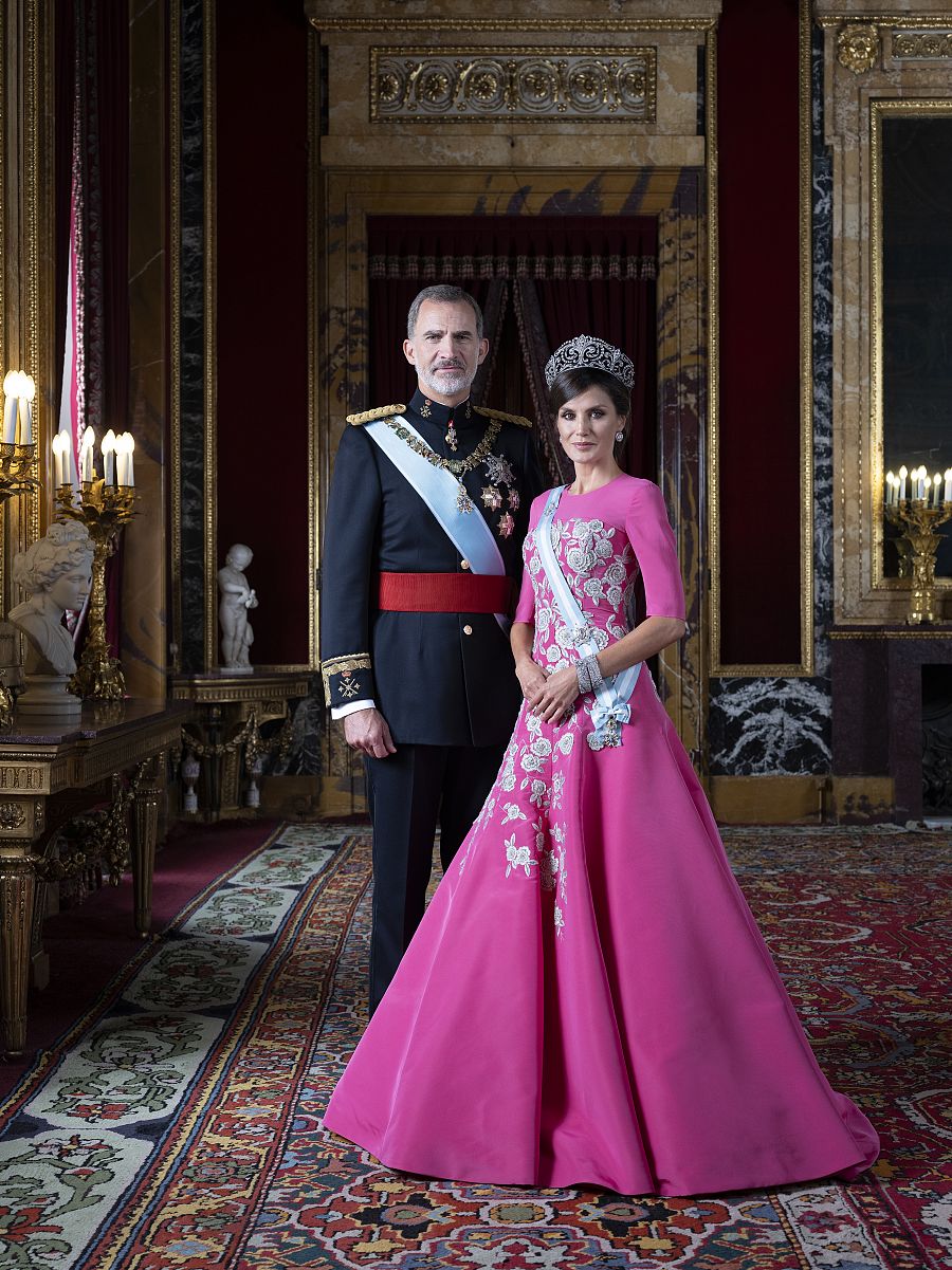 El rey Felipe VI y la reina Letizia en su nueva fotografía oficial conjunta en el Palacio Real. En esta ocasión, ambos visten sus atuendos de gala.