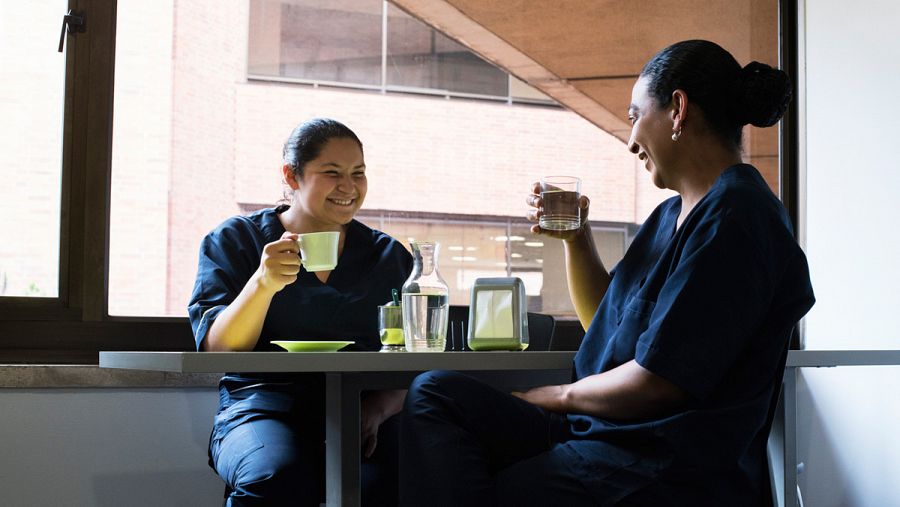 Dos empleadas hacen una pausa para tomar un café