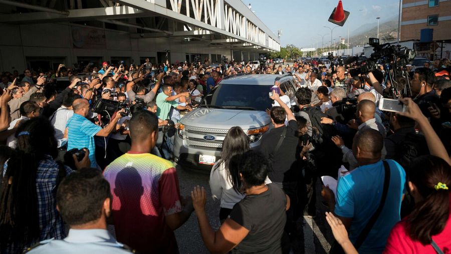 La multitud venezolana, con opositores y simpatizantes del chavismo, se han amontonado alrededor del vehículo en el que Guaidó ha abandonado el aeropuerto.