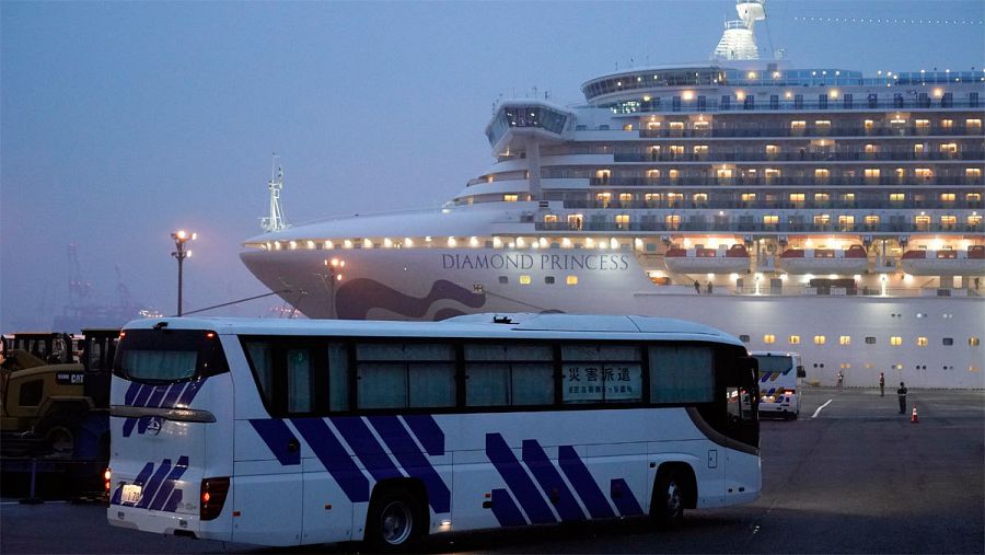 Un autobús junto al crucero Diamond Princess, en cuarentena por coronavirus