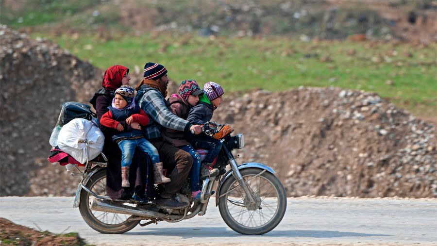Una familia llega en motocicleta al campo de refugiados de Deir al-Ballut, cerca de la frontera siria con Turquía