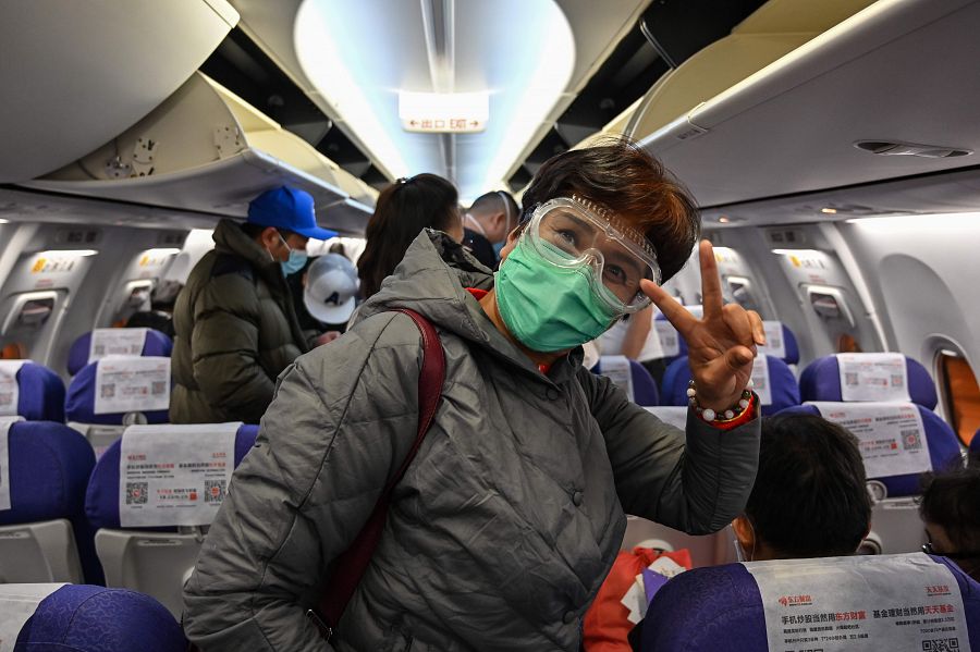 Un pasajero con mascarilla para prevenir el contagio por coronavirus, en un avión en Shanghai.