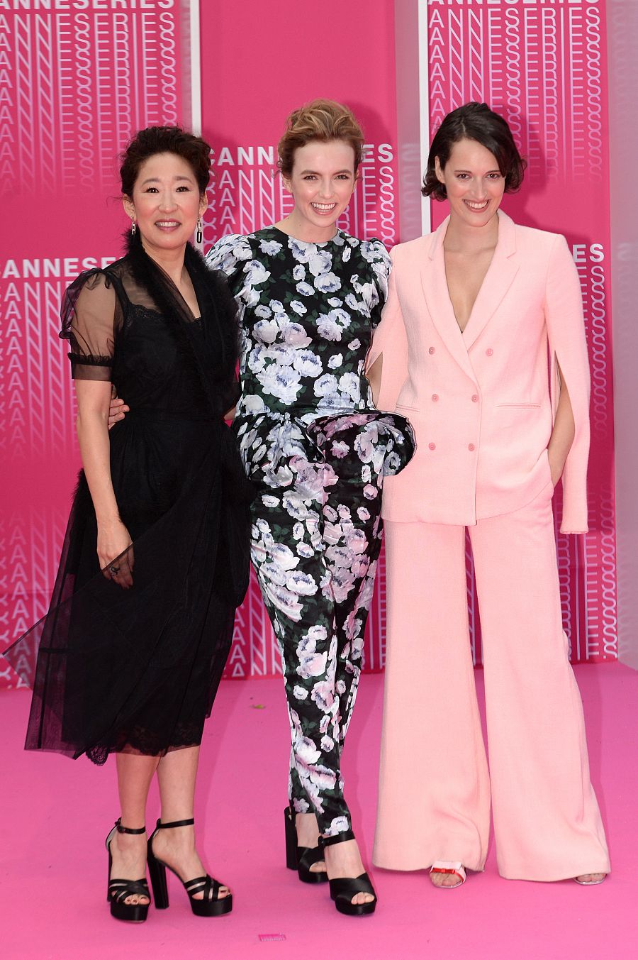 Sandra Oh y Jodie Comer junto a la creadora de la serie, Phoebe Waller-Bridge, en un traje rosa