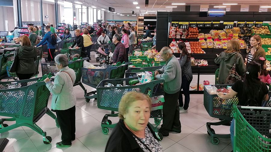 Decenas de personas hacen cola ante las cajas de un supermercado