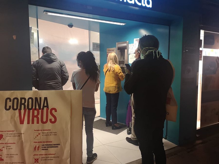 Personas esperan a las puertas de una farmacia de Madrid donde se limita el número de personas que pueden acceder al mismo tiempo