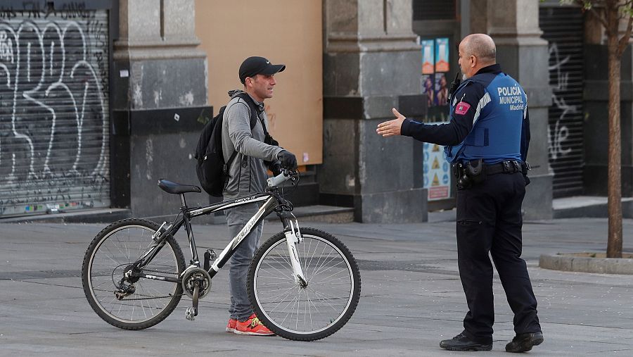 Un policía de Madrid informa a un ciudadano de la prohibición de montar en bici.