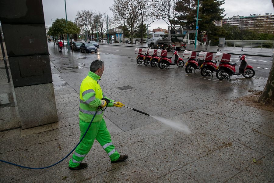 Empleados municipales limpian las calles vacías.