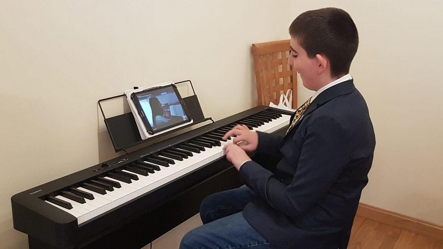 Chechu, de 12 años, sigue su clase de piano en streaming. Mantener su rutina es esencial para las personas con TEA.