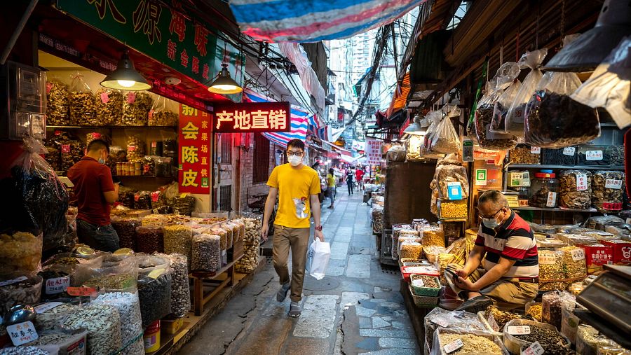Un hombre camina por un mercado de Guangzhou