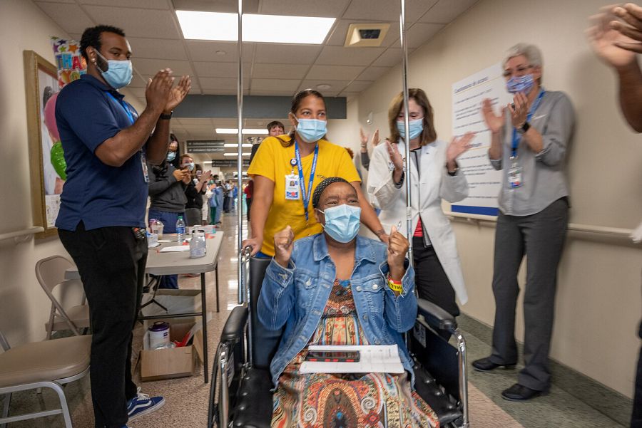 El personal médico aplaude a la paciente a su salida del centro médico Ochsner en Luisiana