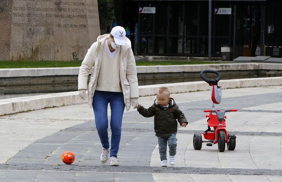 María Zurita juega con su hijo en una plaza con una pelota durante el alivio de la cuarentena para los niños