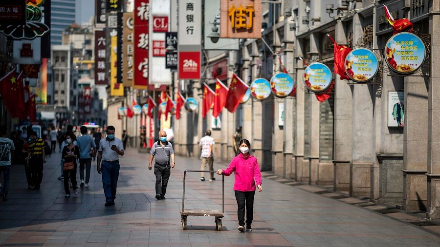 Varias personas pasean por las calles de Guangzhou, China