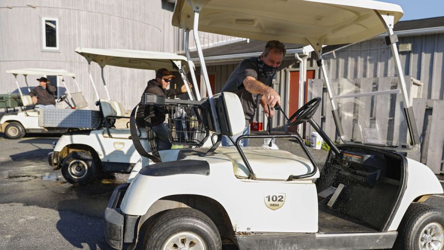 Imagen: Operarios desinfectan un buggie en un campo de golf estadounidense