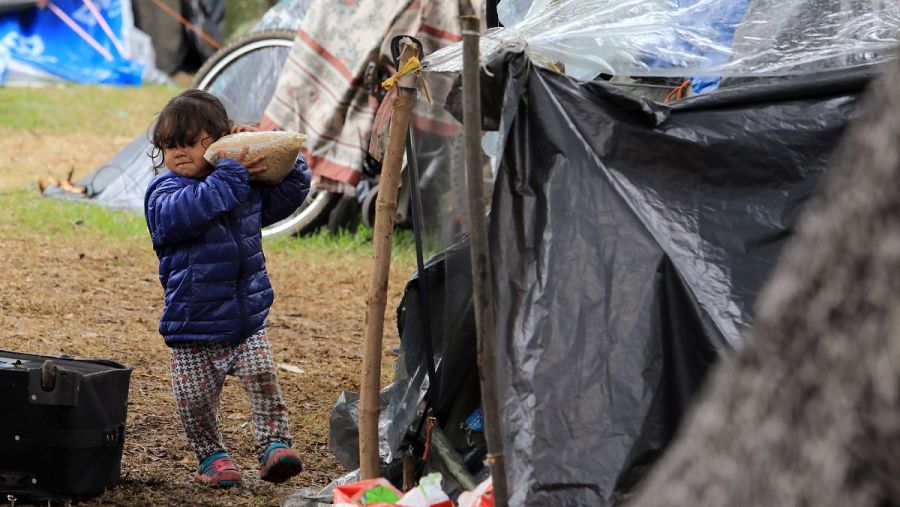 Una niña lleva una bolsa de comida en un campamento improvisado donde permanecen migrantes venezolanos sin empleo y sin hogar en Bogotá, Colombia en junio de 2020.