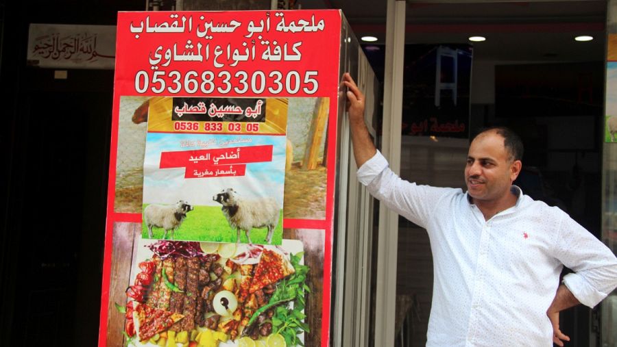 El carnicero Abu Husein, refugiado sirio, posa delante de su carniceria en el barrio de Esenyurt, en Estambul, Turquía, en julio de 2019.