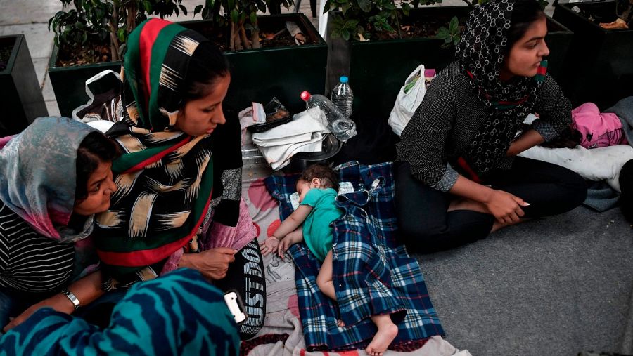Mujeres refugiadas sentadas junto a un bebé dormido, entre las familias afganas que llegaron del campamento de Moria en la isla de Lesbos, a un campamento situado en una plaza del centro de Atenas, este junio.