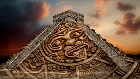 Fotomontaje de una pirámide maya con una de las caras del calendario maya sacando la lengua.