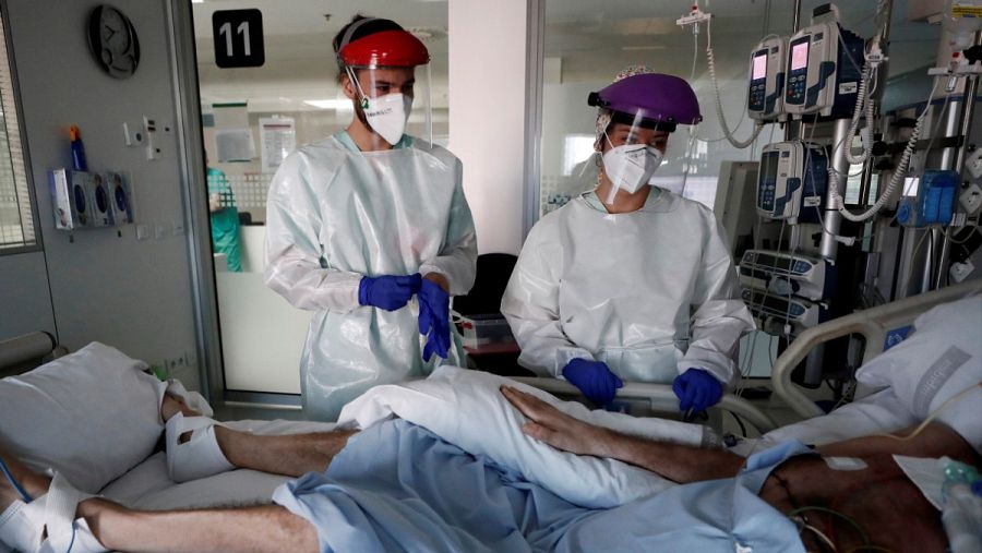 Dos sanitarios atienen a un paciente ingresado en plena pandemia