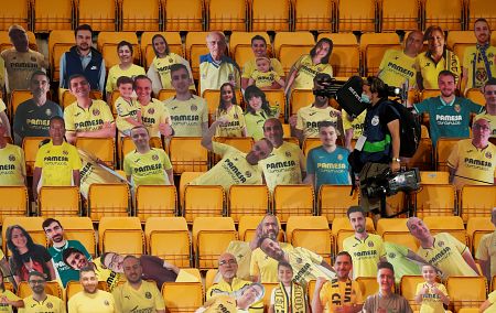 Un cámara, entre recortables de cartón de aficionados del Villarreal en la grada de La Cerámica antes del partido ante el Barça