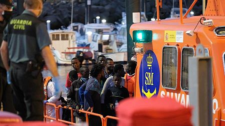Un grupo de inmigrantes irregulares llega a puerto donde les toman la temperatura.