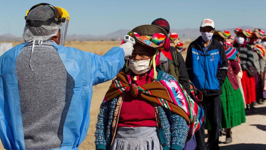 Trabajadores sanitarios comprueban la temperatura a los residentes de las comunidades vecinas a un mercado en Coata, cerca de la frontera con Bolivia, donde se ha detectado un brote del virus.