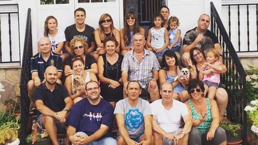 Ricardo Riesco Fernández y su esposa rodeados de toda su familia en las escaleras de su casa.